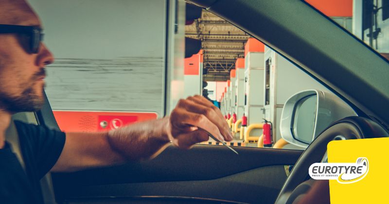 Conducteur au volant à un télépéage autoroute